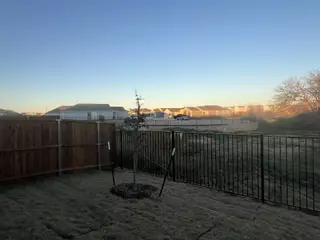A serene backyard with a wooden fence and open view in Foree Ranch: Watermill Collection by Lennar, Providence Village, TX.