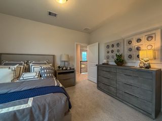 A cozy bedroom with modern decor, featuring a stylish bed, elegant dresser, and warm lighting.