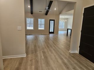 Model Home Entryway leading into a large open living space with high ceilings, modern chandelier, and a view of the outdoors.