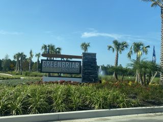 Street view A welcoming entrance with a modern sign and lush landscaping at The Landings at Saint Johns by Pulte Homes (St. Johns, FL).