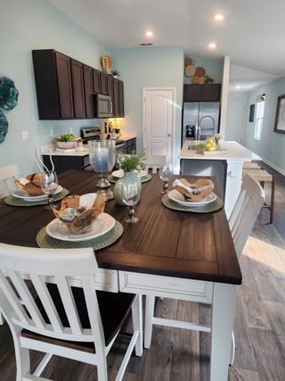 A stylish dining space featuring a dark wood table, chic decor, and a warm, inviting ambiance.