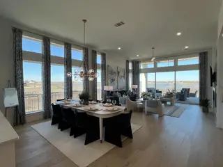 Expansive living area with panoramic windows, modern furnishings, and elegant lighting, offering serene outdoor views.