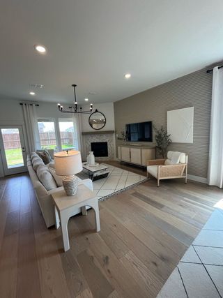 Model Home A cozy living room with hardwood floors, sleek furnishings, and a stylish fireplace, ideal for relaxation and entertaining.