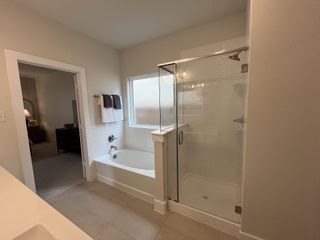 Model Home A bathroom featuring a soaking tub, glass-enclosed shower, and neutral decor.