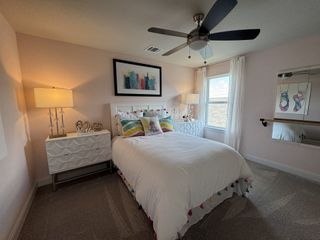A cozy bedroom featuring a plush bed with colorful pillows, elegant lamps, and tasteful artwork for a serene ambiance.
