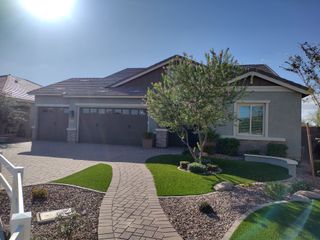 Street view Beautiful home with a brick driveway and lush landscaping in Sonoma Coast at Escalante by Fulton Homes (Surprise, AZ).