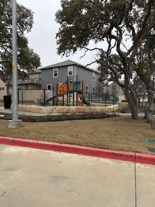 Community Amenities A well-maintained playground with swings and slides, ideal for family fun in the Cove at Westover Hills community by KB Home (San Antonio, TX).