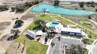 Aerial view of scenic amenities with a pool and lush greenery in Lariat 45' by Perry Homes (Liberty Hill, TX).