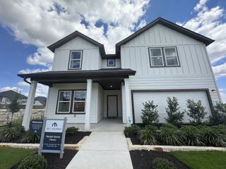 A modern white two-story home with sleek landscaping in Cascades at Onion Creek by M/I Homes (Austin, TX).
