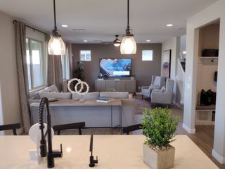 A modern living area with sleek lighting, cozy seating, and a stylish entertainment setup. Neutral tones and elegant decor.