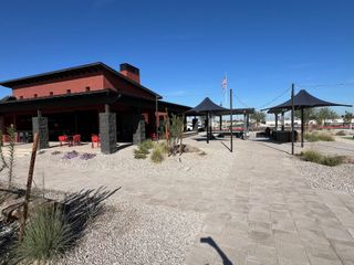 Community Amenities A modern community center with shaded seating areas in Silva Farms by Meritage Homes (Goodyear, AZ).