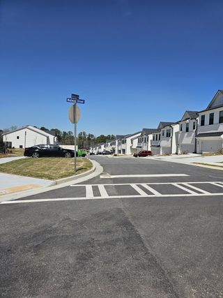 A row of modern townhomes with clean lines and landscaped sidewalks in Azalea Square Townhomes by Century Communities (Lawrenceville, GA).