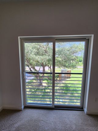 A bright room with a large window view, overlooking lush greenery and featuring plush carpeting.