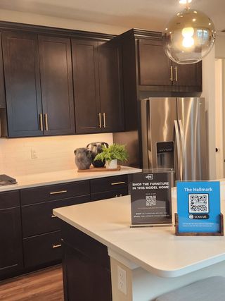 A modern kitchen with rich dark wood cabinets, stainless steel appliances, and elegant pendant lighting.