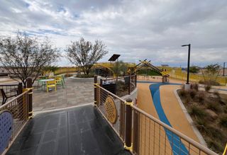 A vibrant playground with colorful seating and winding paths in Laurel at Blossom Rock by Brookfield Residential (Apache Junction, AZ).