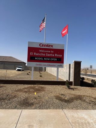 A welcoming sign for El Rancho Santa Rosa by Centex in Maricopa, AZ, with American and Centex flags waving proudly.