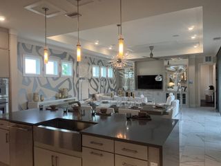 A stunning gourmet kitchen with pendant lighting, a waterfall island, and an elegant dining space with bold accent walls.
