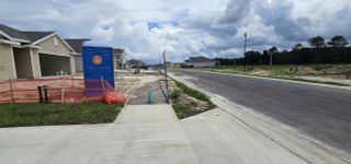 Street view New construction homes with fresh concrete pathways in Avalon Woods by Maronda Homes, Newberry, FL.