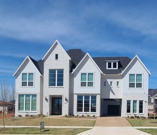 A stunning modern white brick home with elegant windows in Silverleaf Estates by Grand Homes (Frisco, TX).