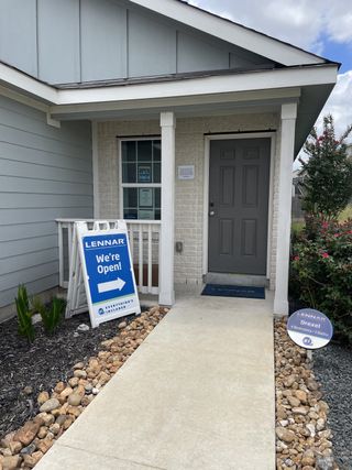 Street view A welcoming entrance to a Lennar model home in Knox Ridge (Converse, TX), featuring a "We're Open!" sign, a paved walkway, and a view of the "Drexel" floorplan details.