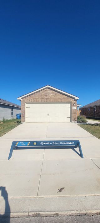 Street view A charming brick home with a spacious driveway in Preserve at Medina by LGI Homes (San Antonio, TX).