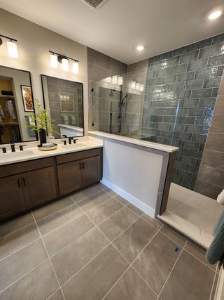 A modern bathroom with a glass-enclosed shower, sleek dual vanity, and elegant tile flooring.