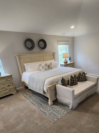 A cozy bedroom with a plush, king-size bed, elegant decor, and soothing neutral tones, perfect for relaxation.