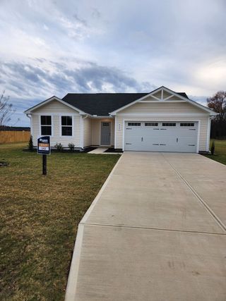 Street view A charming beige ranch-style home with a spacious driveway in Williams Run by Ryan Homes (Bailey, NC).