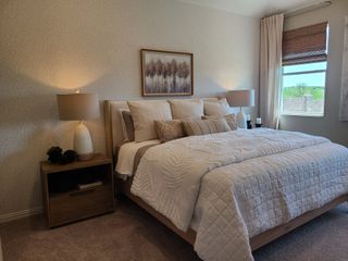 A serene bedroom with elegant bedding, soft lighting, and a large window offering natural views. Perfect for relaxation.