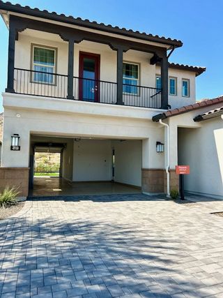 A modern home with a terrace and driveway in the Highlands at Verrado by Capital West Homes (Buckeye, AZ).