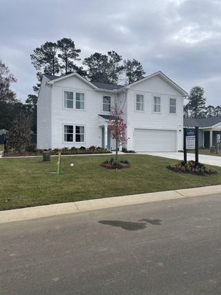A charming white two-story home with a landscaped yard in Essence at Chandler Crossing by Stanley Martin Homes (Summerville, SC).