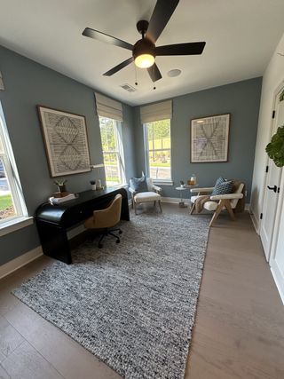 A modern home office with sleek furniture, decorative art, and ample natural light.