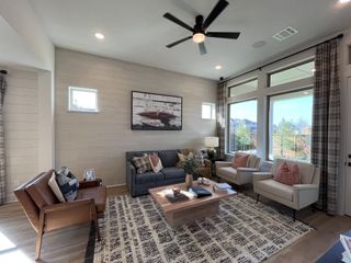 A cozy living room with stylish furniture, warm tones, and large windows in Solterra by David Weekley Homes (Mesquite, TX).