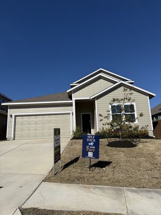 A modern beige home with a two-car garage and landscaped yard in Orchard Ridge by Pacesetter Homes (Liberty Hill, TX).