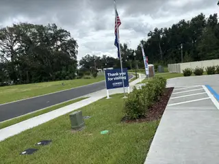 A welcoming drive with lush greenery in Autumn Glen by D.R. Horton, Belleview, FL.