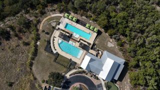 Community Amenities An aerial view of a stunning pool area surrounded by nature in Sweetwater by Chesmar Homes (Austin, TX).