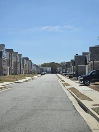 A picturesque street in The Beacon at Old Peachtree by Stanley Martin Homes, Lawrenceville, GA, showcasing modern townhomes.