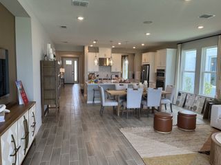An inviting open-concept living area featuring a modern kitchen, elegant dining setup, and cozy living space with ample natural light.