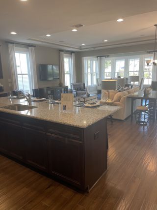 An open-concept kitchen and living area with granite countertops, hardwood floors, and ample natural light.