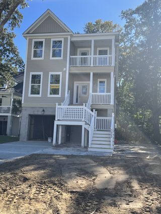 A modern three-story home with double balconies in The Retreat at Brownswood by Eastwood Homes (Johns Island, SC).