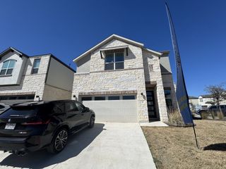 Street view A beautifully designed model home featuring stone exteriors and black accents in Chester Ranch Place by Pinehurst Homes (Round Rock, TX).