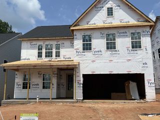 Street view A modern two-story home under construction in Eckley by Tri Pointe Homes in Mooresville, NC, featuring a large garage.