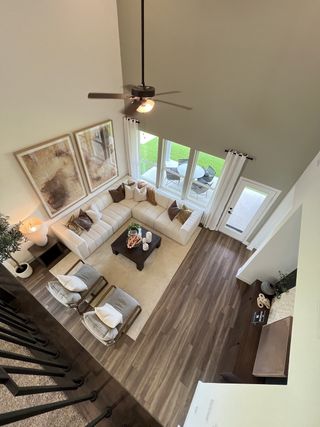 An elegant living room with a plush L-shaped sofa, chic decor, and large windows offering natural light and outdoor views.