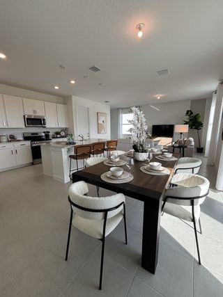 A modern open-concept dining and kitchen area with sleek furnishings and ample natural light.