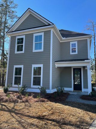 A charming gray two-story home with white trim in Pineland Village by Center Park Homes (Summerville, SC).