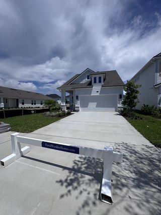 Street view A beautiful two-story white home with a large driveway in Seabrook Village 40' Front Entry by David Weekley Homes (Nocatee, FL).