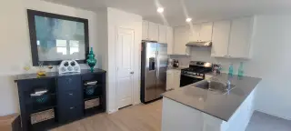 A modern kitchen featuring stainless steel appliances, sleek cabinetry, and a spacious island with integrated sink.