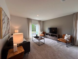 A cozy living room with modern decor, featuring a large TV, plush seating, and soft lighting.