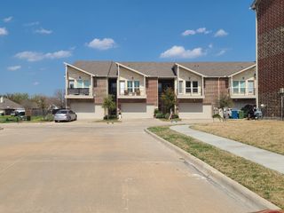 Two-story brick townhomes with modern balconies and garages in Brentwood Court by Havendale Homes (The Colony, TX).