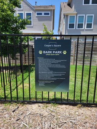 Community dog park with fenced area and rules sign in Coopers Square by Legacy Communities, Austin, TX.